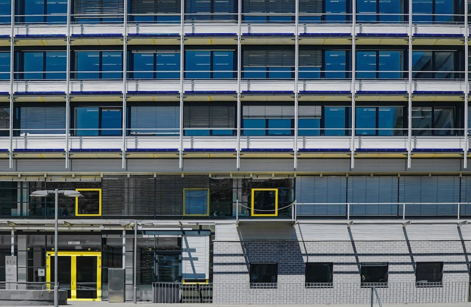 The modern glass facade of the FLUX Digital Partners office building in Vilnius.